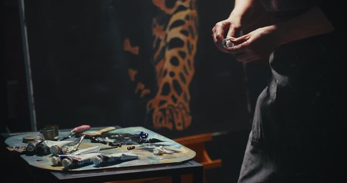 Man Painting Leopard Portrait in Dark Studio