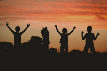 Silhouette of a group of children playing at sunset