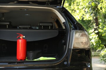 Red fire extinguisher in trunk. Car safety equipment