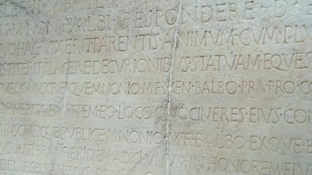 Ancient Roman Latin text chiseled into a white marble slab from the historic town of Herculaneum in Naples, Italy.
