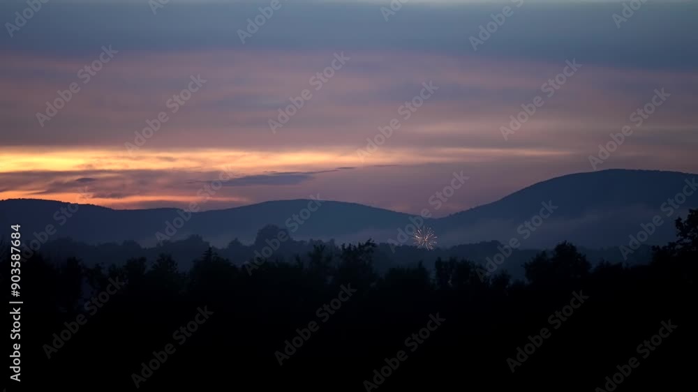 Poster blue hour dusk glow in sky as fireworks launch and explode above treeline in front of mountains in s