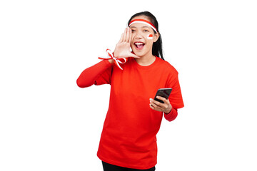 An Indonesian woman celebrating Indonesia's independence day on 17 August while holding smartphone...