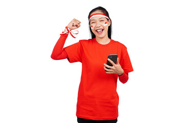 An Indonesian woman celebrating Indonesia's independence day on 17 August while holding smartphone...