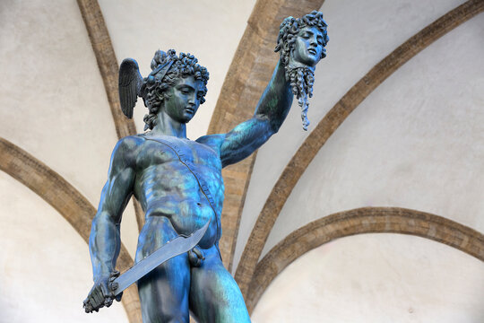 Florence, Tuscany, Italy. June 16, 2024: Perseus with the Head of Medusa, under Loggia dei Lanzi against Palazzo Vecchio
