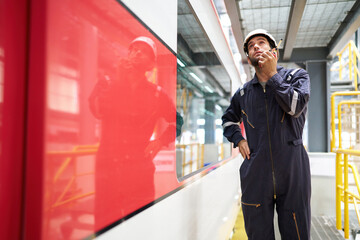 Technician or worker talking about work on walkie talkie and checking at construction train station