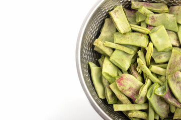 A bowl of broken lentils on a white background