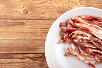 A plate of cut pig ears on the table