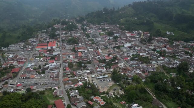 Aerial tilts down to charming streets of Salento Colombia on mtn ridge