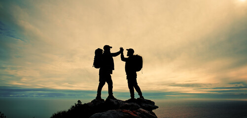 High five, silhouette and winner with friends on mountain peak together for fitness, hiking or view...