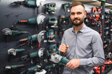 Confident smiling salesman on foreground in power tools store