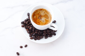 エスプレッソに牛乳をたっぷり入れたコーヒー、カフェ・ラッテと、深煎りしたコーヒー豆
