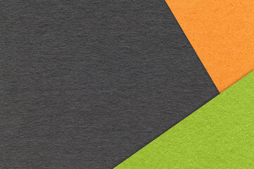 Fototapeta premium Texture of craft black color paper background with orange and green border. Vintage abstract cardboard.