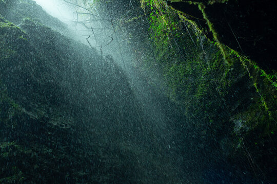 Creative and artistic composition in the Cueva del Esplendor, cave of splendor, Jardin, Jard&iacute;n, Antioquia, Colombia. Dark abstraction with rain falling on a rock and droplets in a ray of light.