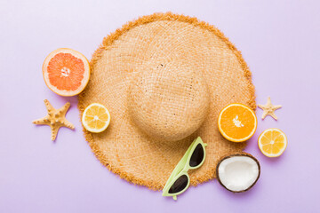 Top view of various seashells placed near colorful fruit and stylish summer accessories on table...