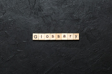 Glossary word written on wood block. Glossary text on cement table for your desing, Top view concept