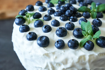 Meringue cake with fresh blueberries and mint, close-up