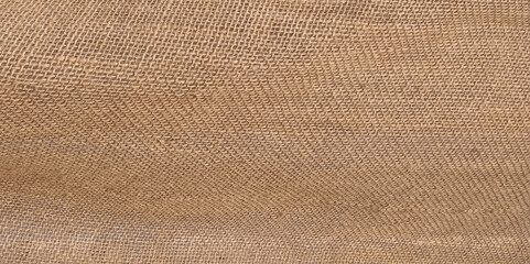 Close-up of fabric woven from burlap. Beige jute texture background.