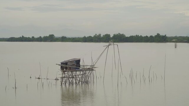 Aerial view of fishing trap net in canel with fisherman urban city village town houses, lake or river. Nature landscape fisheries and fishing tools at Pak Pha, Songkhla, Thailand. Aquaculture farming