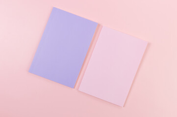 Top view of pink and purple notebooks on pink background. School, office wallpaper. Flat lay, copy space.