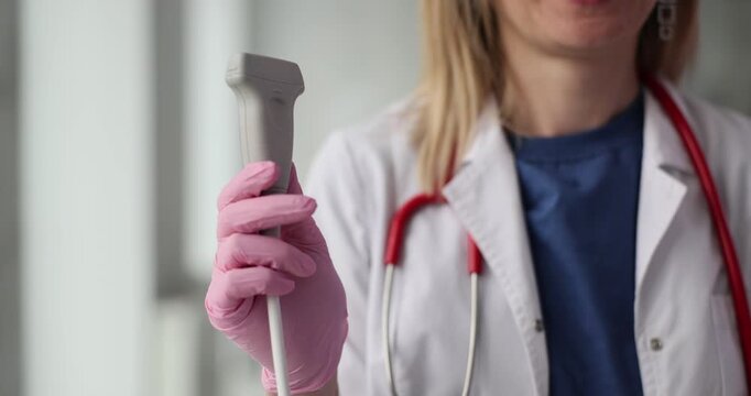 Doctor holds ultrasound probe and ultrasound machine in hand