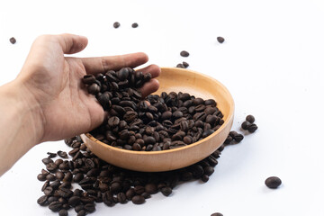 isolated photo of coffee beans in a wooden bowl held by hand, on a white background
