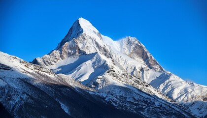 Obraz premium Majestic Heights: Snow-Covered Mountain Peak Under Clear Blue Skies