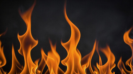 Flames dancing in darkness, bright orange fire against black background creates dramatic contrast.