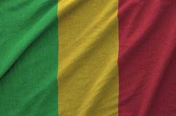 Mali flag depicted on folded wavy fabric of old cloth close up