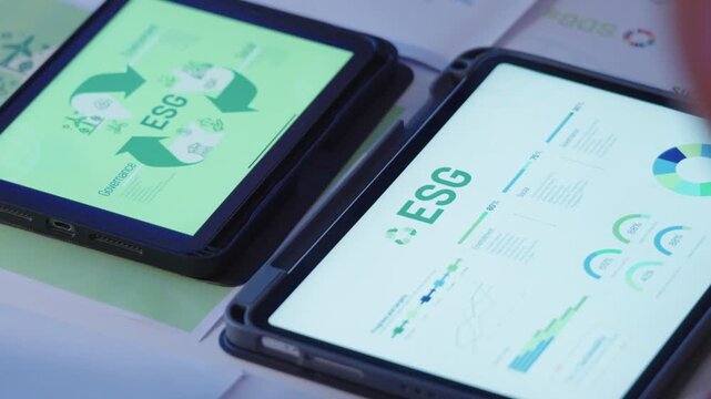close up diversity team brainstorming focused on ESG (environment,social,governance)  with tablet or sdgs goals in a sustainable green office at night