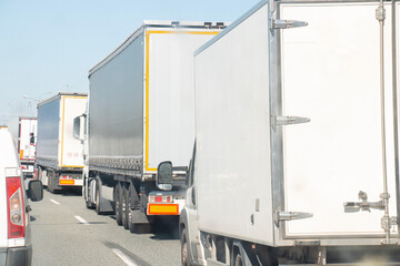 Trucks in a traffic jam at the customs office of the border zone, waiting for a train