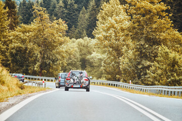 cycle carrier attached to the rear with two bicycles is driving on the freeway