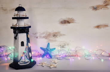 Image of old lighthouse and starfish over white shelf and pastel wooden background. For mockup