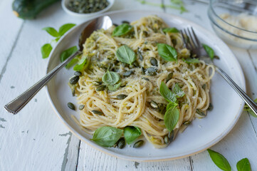 Healthy vegetarian pasta dish with spaghetti in a delicious zucchini, parmesan sauce and pumpkin...
