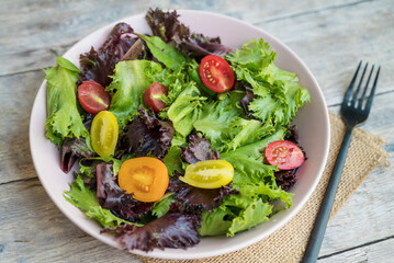 Mix of fresh green salad with red and yellow cherry tomatoes 