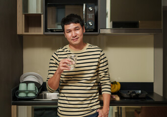 man holding a glass of clean water in home kitchen