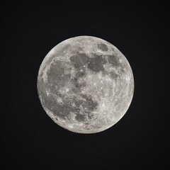 Fototapeta premium Close up view of a night full Moon reveals its rugged terrain, with craters, mountains, and valleys
