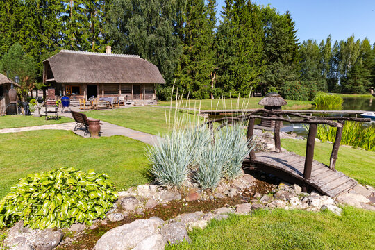 Beautiful park with a lake and an old wooden bridge and arbor surrounded by pine forest in Sodeliskiu dvaras hotel, Birzai, Lithuania