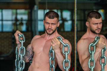Obraz premium Portrait of handsome sporty man with muscular body doing weight lifting. Guy workout at gym. Fitness trainer, sport instructor, sporty man, fit model sportsman workout. Power athletic guy bodybuilder.