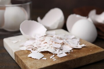 Pieces of broken eggshells on wooden table, closeup