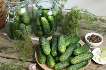 Fresh cucumbers, dill and spices on wooden table, closeup. Preparation for pickling