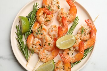 Skewers with delicious grilled shrimps served on white table, top view