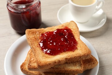 Delicious toasted bread slices with jam served on wooden table, closeup