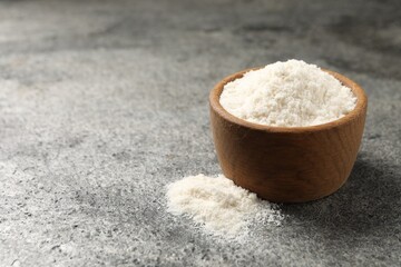 Organic coconut flour in bowl on grey table. Space for text
