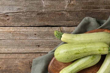 Raw green zucchinis on wooden table, top view. Space for text
