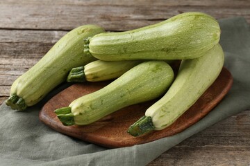 Raw ripe green zucchinis on wooden table