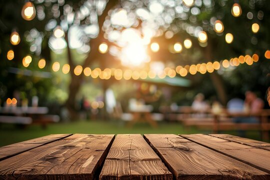 Ein leerer Holztisch bei einer Gartenparty im Sommer, verschwommener Bokeh Hintergrund 