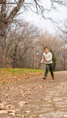Obraz premium Caucasian boy 8 years old running in nature in a park in autumn