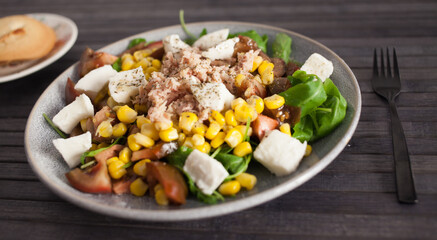 Fish salad with canned tuna and corn, tomatoes and arugula