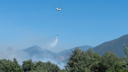 fire helicopter spray water to forest fire