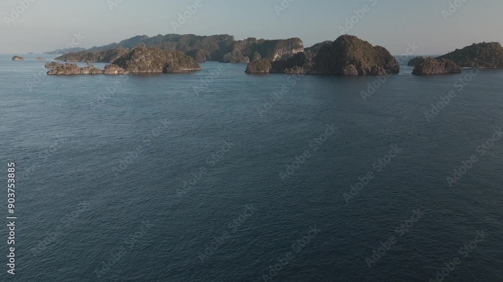 Wall mural Flight over the water surface towards the islands in the sea. Raja Ampat region, Misool, West Papua, Indonesia